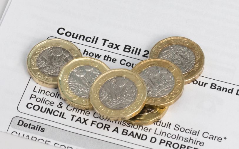 Council tax bill with pound coins.