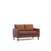 Tan two seater sofa in a dark room