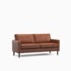 Tan three seater sofa in a dark room