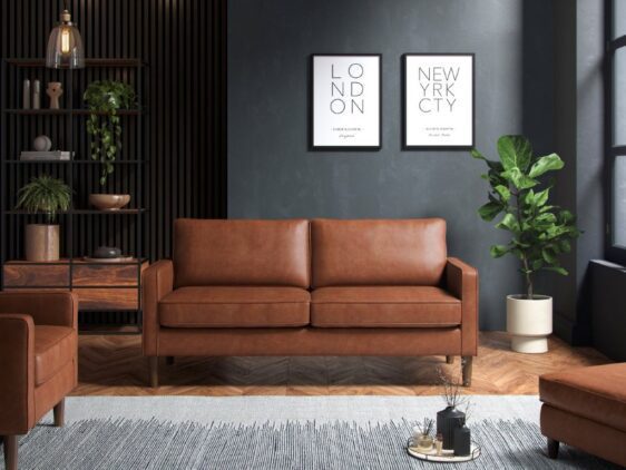 Tan three seater sofa in a dark room